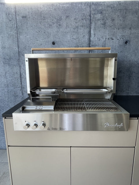 Outdoor kitchen by the pool with Flammkraft grill: front in gray-beige beneath the concrete roof