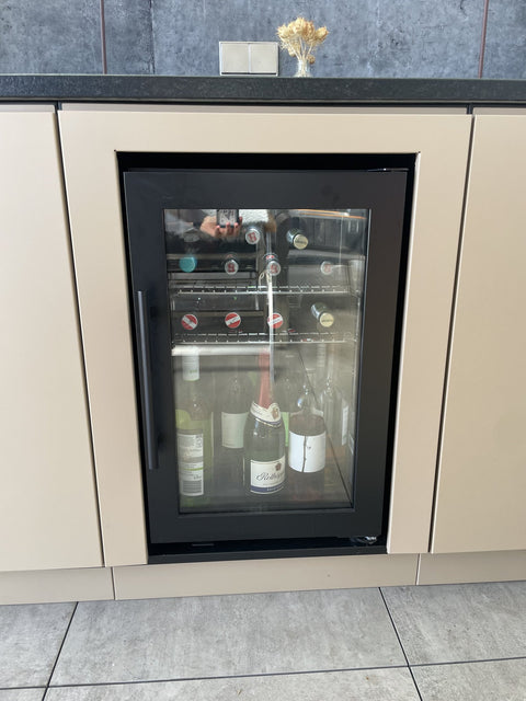 Outdoor kitchen by the pool with Flammkraft grill: front in gray-beige beneath the concrete roof