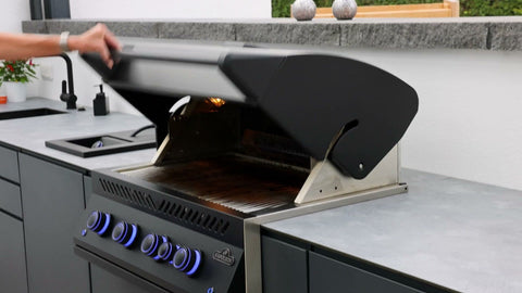 Outdoor kitchen along the garden wall: long kitchen unit in anthracite beside the dining area