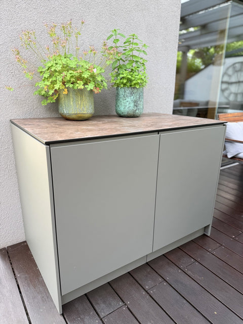Outdoor kitchen on the wooden deck: Mia in quartz gray with a Napoleon grill and cabinet unit