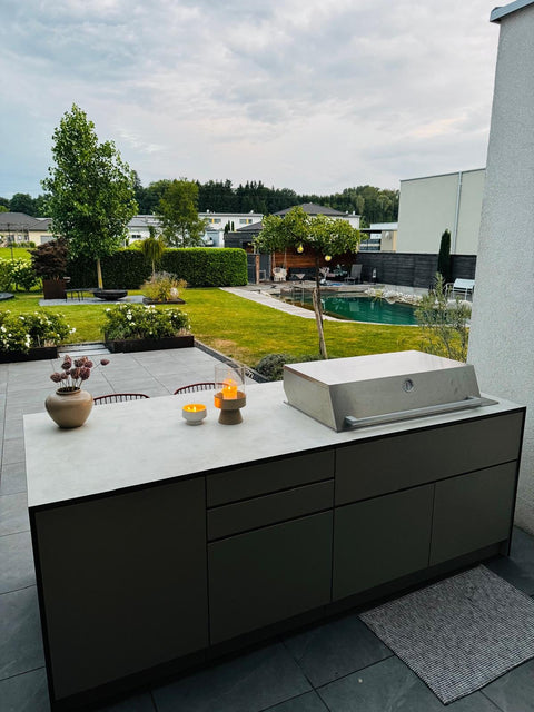 Outdoor kitchen as a cooking island with a bar counter: grill at the front, sit at the back