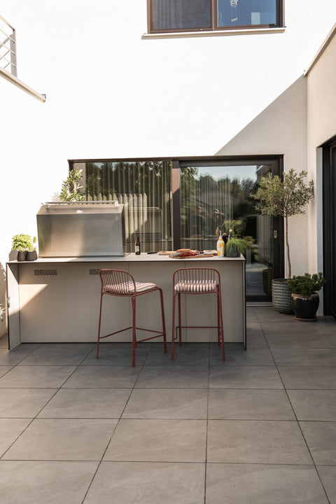 Outdoor kitchen as a cooking island with a bar counter: grill at the front, sit at the back